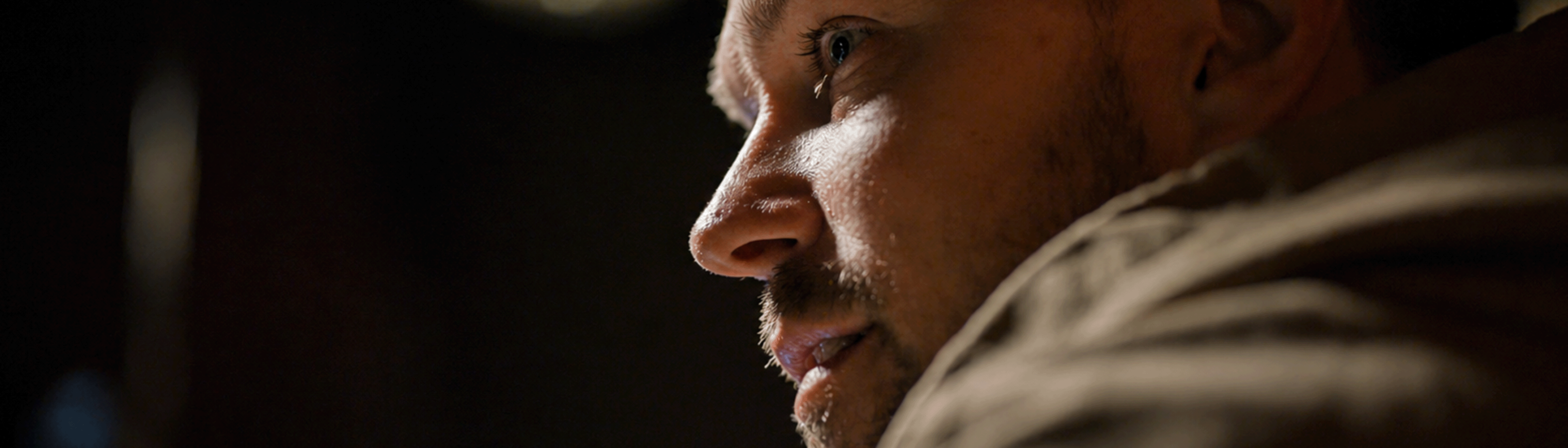 Ricky Seaman in profile, half-lit at the table